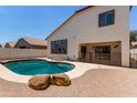 A private backyard oasis offers a refreshing pool, a covered patio, and a paved deck for relaxing at 15811 N 155Th Dr, Surprise, AZ 85374