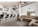 Bright and open living room with staircase features a large sectional sofa, and neutral decor at 15811 N 155Th Dr, Surprise, AZ 85374