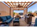 Inviting outdoor patio with pergola, ceiling fans, comfortable seating, barbecue, and dining space at 1662 E Kingman Pl, Casa Grande, AZ 85122