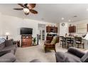 Open concept living room flowing into the kitchen, complete with a ceiling fan and television at 1662 E Kingman Pl, Casa Grande, AZ 85122