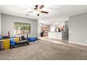 Bright living room showcasing neutral paint, plush carpeting, and open floor plan into the kitchen at 17562 W Gelding Dr, Surprise, AZ 85388