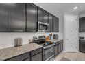 Modern kitchen features granite counters, stainless steel appliances, white subway tile backsplash, and sleek dark cabinetry at 1960 N Loretta Pl, Casa Grande, AZ 85122