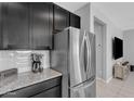 Kitchen with stainless steel appliances, granite countertops, sleek dark cabinets, and a tiled backsplash at 1960 N Loretta Pl, Casa Grande, AZ 85122