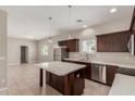 A modern kitchen showcasing an island, stainless appliances, ample counter space, and dark cabinets at 2000 N 36Th St # 14, Phoenix, AZ 85008
