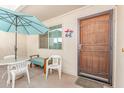 Cozy outdoor patio with table, chairs, bench, umbrella, and secure screen door at 2020 W Union Hills Dr # 156, Phoenix, AZ 85027