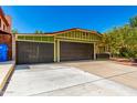 Attractive curb appeal featuring a three car garage, green home, and well-maintained landscaping at 2109 E Gelding Dr, Phoenix, AZ 85022