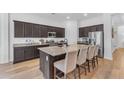 Spacious kitchen island with granite countertop, bar stool seating, stainless appliances, and dark wood cabinets at 2459 E Lindrick Dr, Gilbert, AZ 85298
