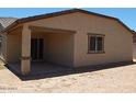 View of the back exterior, with covered patio and sliding glass door at 25744 W Winston Dr, Buckeye, AZ 85326