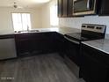 Kitchen features include stainless steel appliances, dark cabinets, granite counters and an island at 25744 W Winston Dr, Buckeye, AZ 85326
