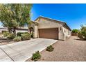 Single-story home featuring a two-car garage and well-maintained front yard with mature landscaping at 25960 W Tonto Ln, Buckeye, AZ 85396