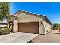 Single-story house featuring a two-car garage with a driveway in a well-kept community at 25960 W Tonto Ln, Buckeye, AZ 85396