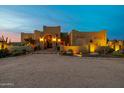 Stunning exterior view showcasing decorative ironwork, desert landscaping, and warm lighting at 38106 N 2Nd Ln, Phoenix, AZ 85086
