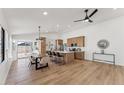 Open-concept living space with wood floors, a ceiling fan, a kitchen island with barstools, and a dining table at 3955 W Cindy St, Chandler, AZ 85226