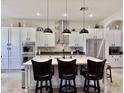 Spacious kitchen showcases a large island with seating, stainless steel appliances, and elegant pendant lighting at 4277 E Blue Sage Ct, Gilbert, AZ 85297