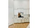 Bright, white kitchen with subway tile, white cabinets, stainless steel appliances, and hardwood floors at 4824 S Brice --, Mesa, AZ 85212