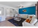 Inviting open-concept living room boasting a dark blue accent wall, plush furniture, and contemporary decor at 4933 W Melody Ln, Laveen, AZ 85339
