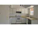 Functional kitchen featuring white cabinets, appliances, and lots of natural light at 5916 W Pierce St, Phoenix, AZ 85043