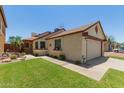 Home exterior showing a two-car garage, mature landscape, and covered front porch at 6319 W Mercer Ln, Glendale, AZ 85304