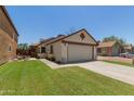 Charming front exterior featuring a two-car garage, well-maintained lawn, and mature landscaping at 6319 W Mercer Ln, Glendale, AZ 85304