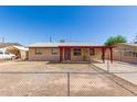 Single-story home featuring a covered porch and a low, chain-link fence around the front yard at 6521 W Flower St, Phoenix, AZ 85033