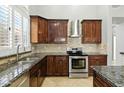 Gourmet kitchen with stainless steel appliances and custom cabinets at 6967 W Irma Ln, Glendale, AZ 85308