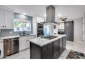 Modern eat-in kitchen featuring marble countertops, an island cooktop, stainless steel appliances, and custom cabinets at 8618 E Via De Encanto --, Scottsdale, AZ 85258