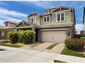 Charming two-story home with a two-car garage, well-maintained lawn, and mature landscaping under a bright sky at 10036 E Naranja Ave, Mesa, AZ 85209