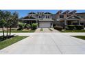 Two-story home features a two-car garage, colorful landscaping, and a well-manicured lawn at 10036 E Naranja Ave, Mesa, AZ 85209