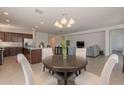 Open dining area with a dark wood table, light colored chairs and an adjacent living area at 10348 E Tupelo Ave, Mesa, AZ 85212
