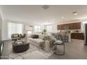 Bright open-concept living room with neutral colors, a view of the kitchen, and modern decor at 10348 E Tupelo Ave, Mesa, AZ 85212