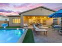 Inviting backyard oasis featuring a swimming pool, patio furniture, and grassy area for relaxation and entertainment at 10650 E Palladium Dr, Mesa, AZ 85212