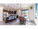 Bright kitchen with stainless steel appliances, dark cabinets, granite counters, and a large center island at 14338 W Bronco Trl, Surprise, AZ 85387