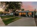 Inviting single-story home boasting a cozy front porch, manicured lawn, and brick paved driveway at 1522 W Willetta St, Phoenix, AZ 85007