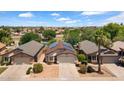 Home with solar panels close to community lake surrounded by mature landscaping at 17115 N Larkspur Ln, Surprise, AZ 85374
