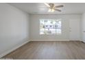 Bright living room featuring stylish wood floors and a large window with a view of the front yard at 17848 N 34Th Ln, Phoenix, AZ 85053