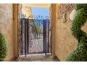 Welcome to a decorative private front patio with a custom iron gate design at 18474 W College Dr, Goodyear, AZ 85395