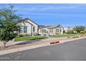Charming single-story home with lush green lawn and well-manicured landscaping at 19910 E Vallejo St, Queen Creek, AZ 85142