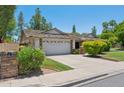 Charming single-story home featuring a well-manicured lawn, mature trees, and a two-car garage with a light brown roof at 2053 W Natal Cir, Mesa, AZ 85202