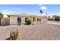 A picturesque single-story home featuring desert landscaping, arched windows, and an attached garage at 3514 W Helena Dr, Glendale, AZ 85308