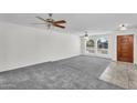Bright and airy living room featuring arched windows, neutral carpet and tiled entry at 3514 W Helena Dr, Glendale, AZ 85308