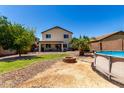 The backyard features a fire pit, above ground pool, desert landscaping and patio at 40316 W Hopper Dr, Maricopa, AZ 85138