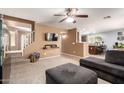 Comfortable living room with a large gray sectional sofa, ceiling fan, and stairway at 40316 W Hopper Dr, Maricopa, AZ 85138