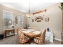 Traditional dining room featuring a wooden table, decorative wall shelves, and carpet flooring at 4067 W Maggie Dr, San Tan Valley, AZ 85144