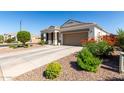 Attractive single-story home with a well-maintained yard and a spacious driveway leading to a two-car garage at 4067 W Maggie Dr, San Tan Valley, AZ 85144