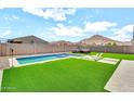 Inviting backyard oasis with pool, artificial turf, and mountain views at 4455 W Suncup Dr, San Tan Valley, AZ 85144