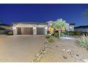 Beautifully landscaped home showcasing a spacious driveway, mature palm trees, and a two-car garage at 5243 E Windstone Trl, Cave Creek, AZ 85331