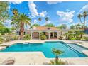 Lush tropical landscaping surrounds the custom swimming pool and spa in the backyard at 5540 E Mercer Ln, Scottsdale, AZ 85254