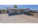 Spacious driveway and covered parking area lead to a charming single-story home at 643 N 92Nd Pl, Mesa, AZ 85207