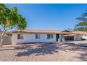 Well-maintained single-story home featuring desert landscaping, a covered carport, and a clear blue sky at 656 E Mesquite Ave, Apache Junction, AZ 85119