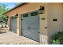 Close-up view of a two-car garage with stylish blue doors and classic exterior lighting at 7202 N 16Th Dr, Phoenix, AZ 85021